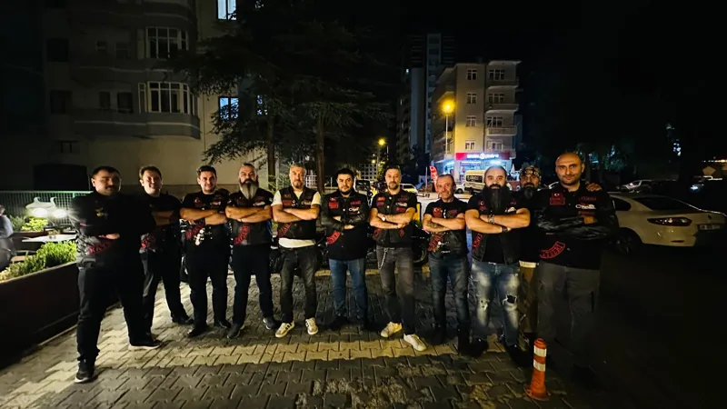 Üyeler gece, kaldırımda yan yana duruyor